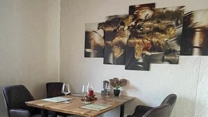Een eetruimte met een houten tafel, vier stoelen en een tapijt met een rood patroon.