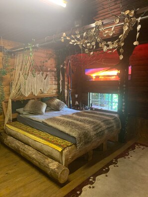 A rustic wooden room with a bed, a window, and decorative elements like macramé and shells. - Chalet Hüttenzauber – Nature Retreat with Panoramic Views, Wi-Fi & Pet-Friendly (Dimbach)
