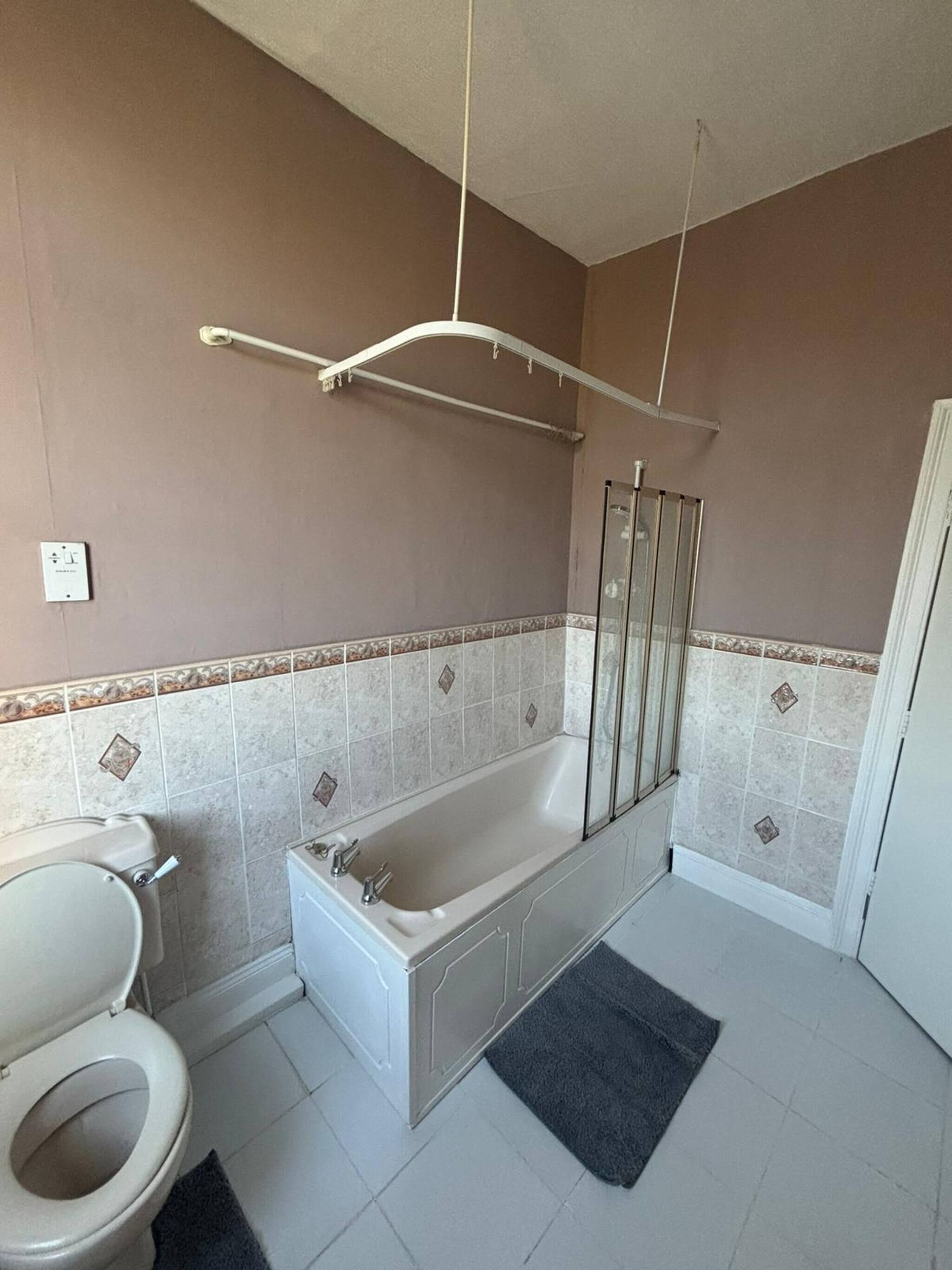 Un baño con bañera, inodoro y zona de ducha.