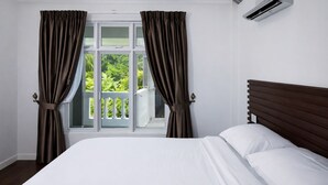 Ein Schlafzimmer mit einem großen Bett, einem Fenster mit Vorhängen und einer Klimaanlage.