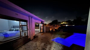 Un edificio moderno con un dormitorio, zona de piscina y patio.