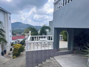 Ein Wohngebäude mit Balkon, Bergblick und einem Fahrrad.