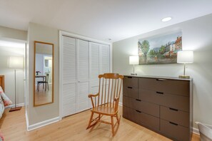 A room with a wooden rocking chair, a dresser, a mirror, and a painting on the wall. - Gateway to Downtown Baltimore! Cozy & Private Unit (Baltimore)