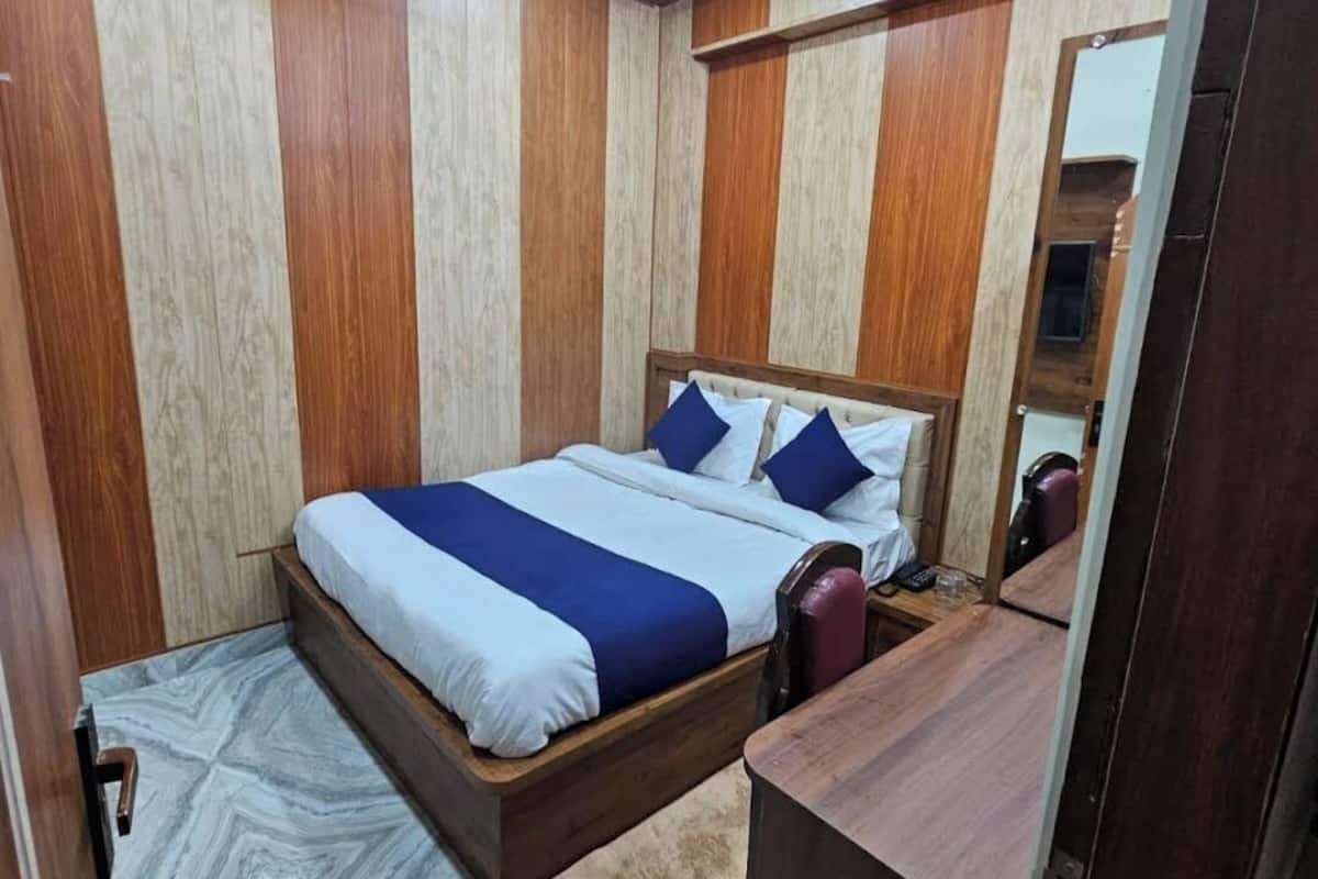 Un dormitorio con una cama, un ventilador de techo y un cabecero de madera.