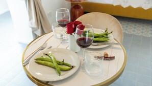 Una mesa de comedor con platos de comida, copas de vino y un jarrón con flores.