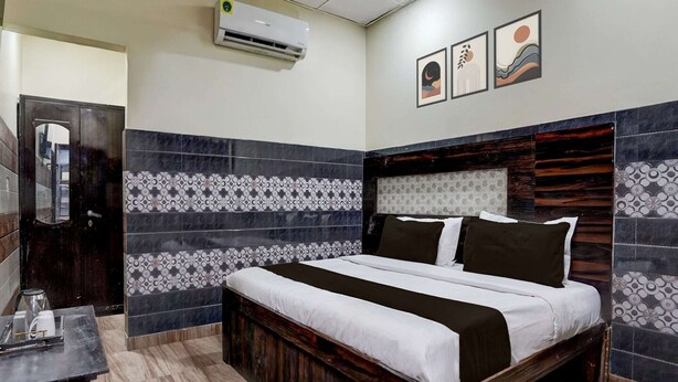 A hotel room with a bed, a desk, and a wall-mounted air conditioner. - Hotel O Mathura Janam Bhumi Link Road (Mathura)