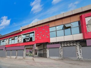 Un hotel con fachada roja, múltiples ventanas y un letrero que indica que es un hotel.