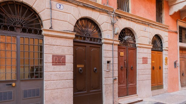 Una hilera de edificios tradicionales de estilo europeo con puertas arqueadas y ventanas numeradas.