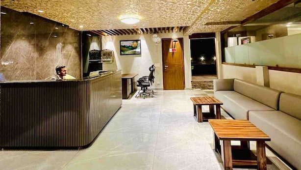 Un espace d’accueil doté d’un plafond en bois, d’un comptoir de réception, d’un canapé et d’une petite table.
