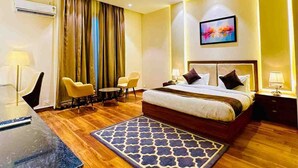 Une chambre d’hôtel équipée d’un lit, d’un bureau, de chaises et d’un ventilateur de plafond.