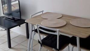Ein Essbereich mit Tisch, Stühlen, einem Fernseher und einem Wandbild.