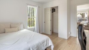 Un dormitorio con cama, armario y vistas al exterior.