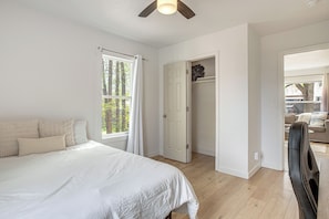 Ein Schlafzimmer mit Bett, Kleiderschrank und Blick ins Freie.