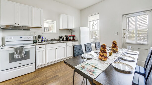 A modern kitchen with white cabinets, a dining table set for four, and a refrigerator. - 1 Mi to Erie Canalway Trail! Condo w/ Grill (Little Falls)