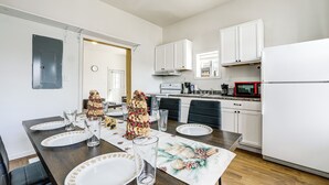 A dining area with a wooden table set for four, white cabinets, a white refrigerator, and a microwave. - 1 Mi to Erie Canalway Trail! Condo w/ Grill (Little Falls)