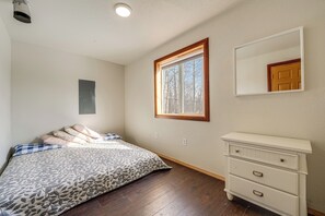 Un dormitorio con cama, cómoda, ventana y puerta.