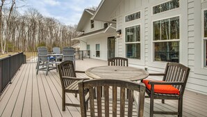 A deck with outdoor furniture, a large window, and a building with white siding. - ADA-Compliant! 'Birch Haven' in Baileys Harbor (Baileys Harbor)