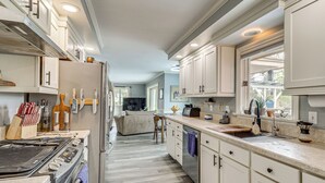 A modern kitchen with white cabinetry, a stainless steel refrigerator, and a built-in oven. - Backyard Oasis w/ Hot Tub & Greenhouse! Toledo Gem (Toledo)
