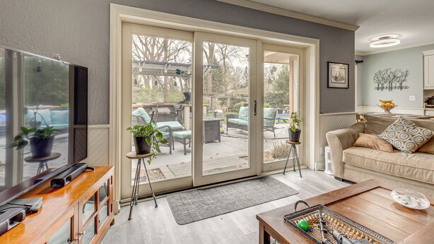A living room with a TV, sofa, and sliding glass doors leading to an outdoor patio. - Backyard Oasis w/ Hot Tub & Greenhouse! Toledo Gem (Toledo)