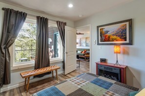 A room with a wooden bench, a quilted rug, a fireplace, and a framed landscape painting. - Private Cabin in the Woods, Mtn Biking, Elk River (Pineville)