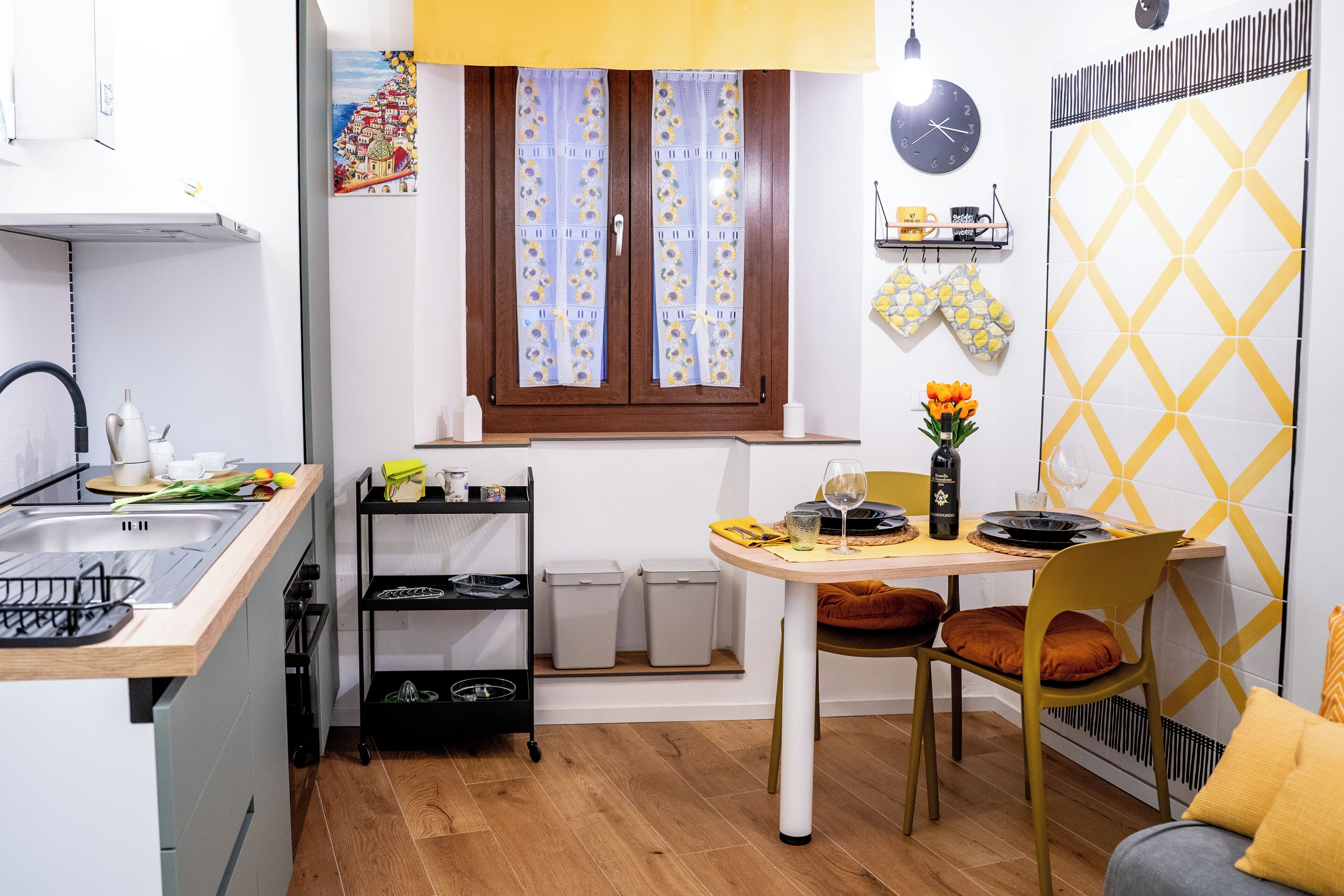Une cuisine compacte comprenant un évier, une cuisinière et un coin repas avec une table et des chaises.
