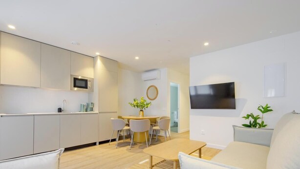 Un appartement moderne comprenant une cuisine, un coin repas et un salon.