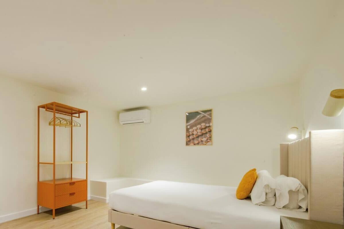 Un dormitorio minimalista con cama, armario y estantería.