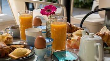 Una mesa de desayuno con diversos alimentos, bebidas y utensilios.