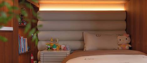 Un dormitorio acogedor con cama, mesita de noche y estante con libros y juguetes.