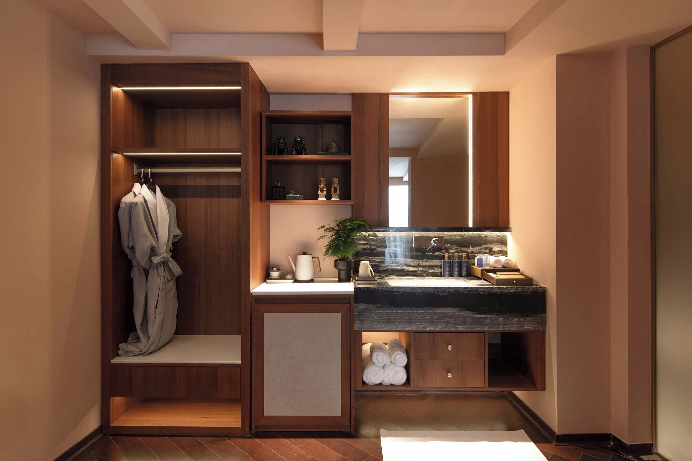 A modern bathroom with a built-in vanity, towel racks, and a large mirror.