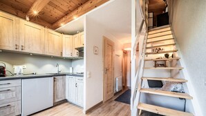 A kitchen with wooden cabinets, a white dishwasher, and a wooden staircase. - Apartment “Côté Soleil” with Mountain View, Balcony and Wi-Fi (Châtel)