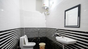Ein Badezimmer mit Toilette, Bidet, Waschbecken und einem Spiegel an der Wand.