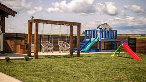 Un parque infantil con columpios, toboganes y una estructura para escalar.