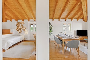 Una habitación con cama, una mesa de comedor con sillas, televisión y ventana con vistas.
