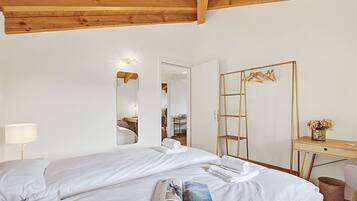 Ein Hotelzimmer mit Bett, Schreibtisch, Spiegel und Lampe.