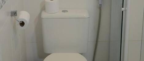 Un baño pequeño y funcional con inodoro, ducha y bidé.