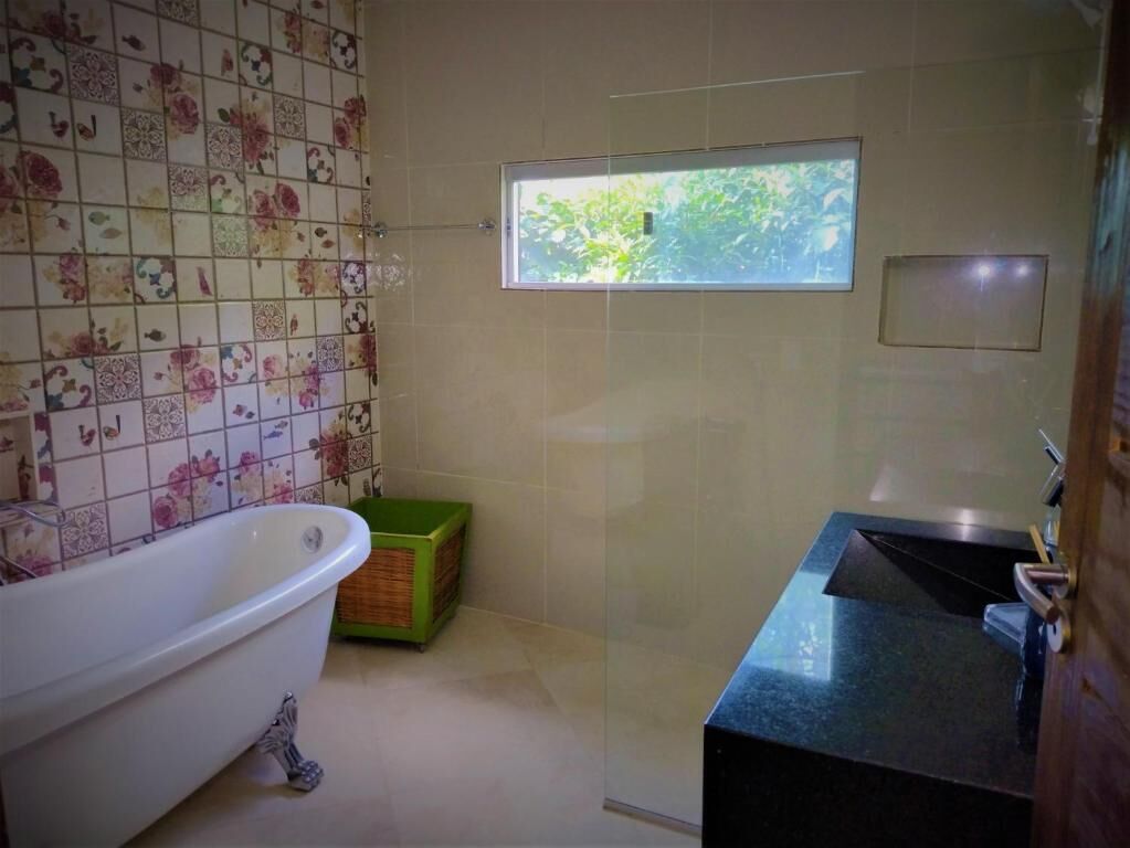 Un bagno con vasca, cabina doccia, finestra e lavabo.
