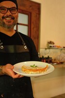 A person holding a plate with a slice of pizza.