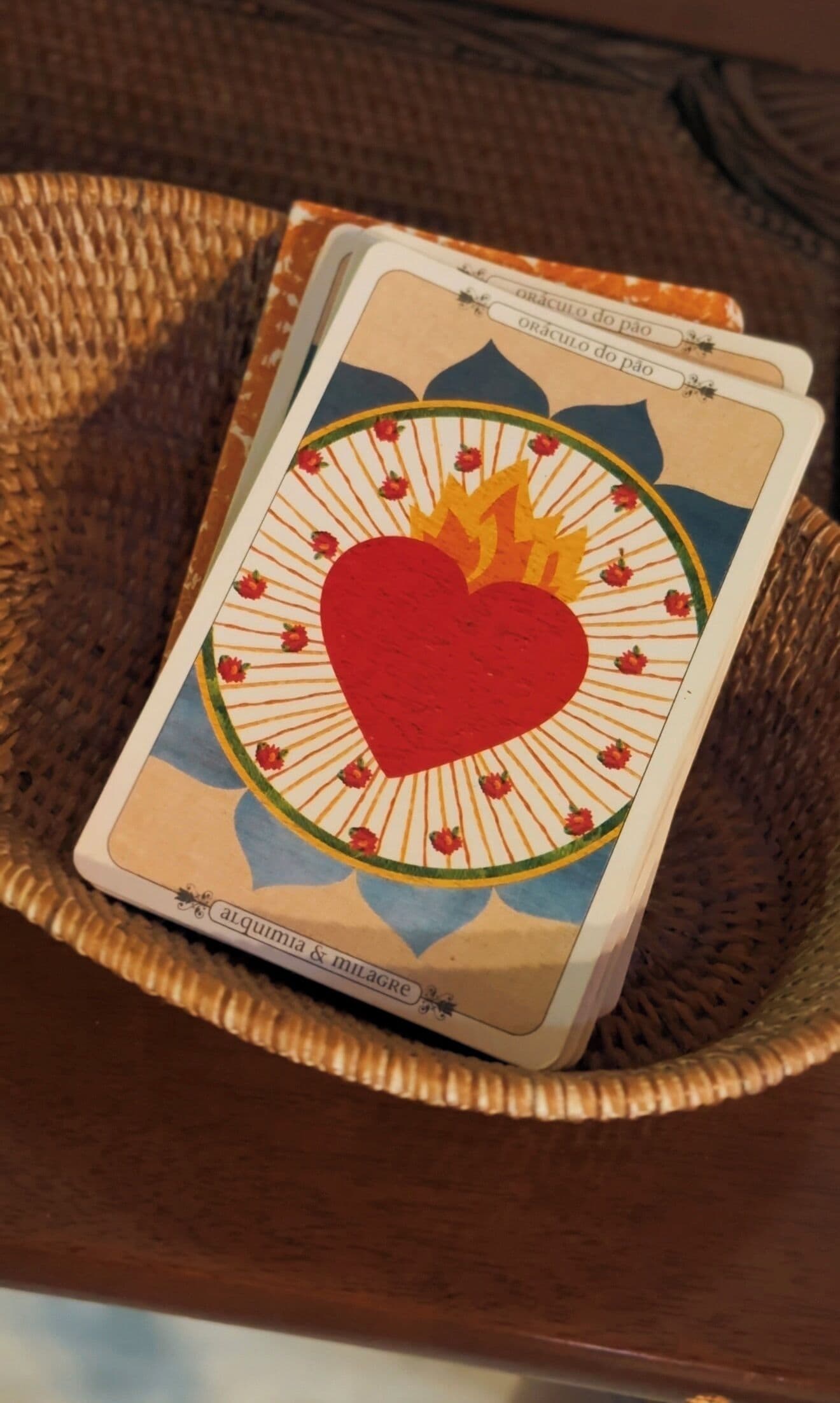 A single tarot card with a heart and flame design, placed on a woven basket.