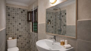 A modern bathroom with a glass-enclosed shower, a white sink, and a large mirror. - Riad Symphony 808 (Fes)