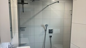 A modern bathroom with a glass shower enclosure, a white sink, and a small potted plant. - Andy's apartment (Malsch)