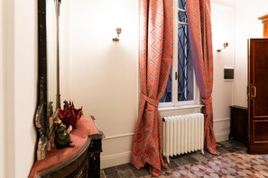 A hallway with a radiator, a mirror, and patterned curtains. - Noble and imperial residence Catullus (Verona)