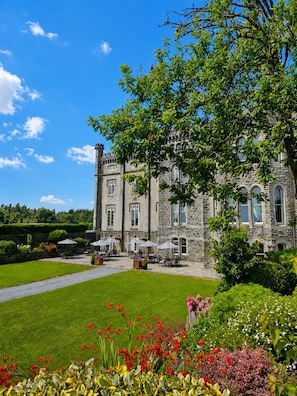 A stone building with a courtyard, outdoor seating, and a well-maintained garden.