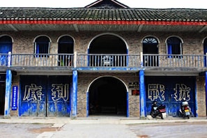 A two-story building with arched windows and a balcony. - Qixinlong Sightseeing Hotel (Zhenyuan County)