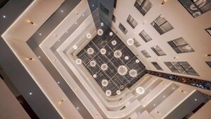 A multi-level atrium with a central open space, multiple floors, and a modern architectural design.