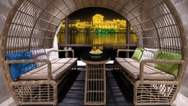 A wicker seating area with a view of a traditional building.