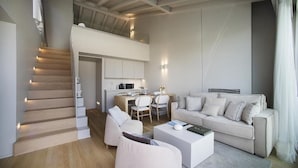 A modern living room with a staircase, a dining area, and a kitchen. - Palazzo Cordigero (Peschiera del Garda)