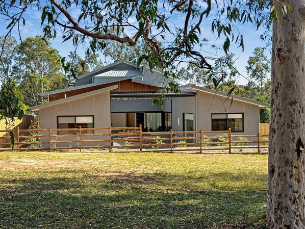 A modern two-story house with a fenced yard, large windows, and a flat roof. - Sereno - Fabulous golf resort getaway (POKOLBIN)