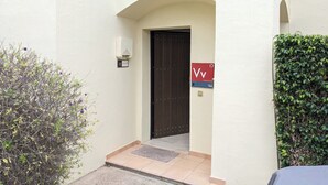 A building entrance with a dark door, a mailbox, and a sign with 'Vv' on it. - 3-bedroom villa in peaceful  Roda Golf with AC (San Javier)
