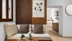 Ein modernes Wohnzimmer mit einer Couch, einem Couchtisch und einem gerahmten Pflanzenbild an der Wand.